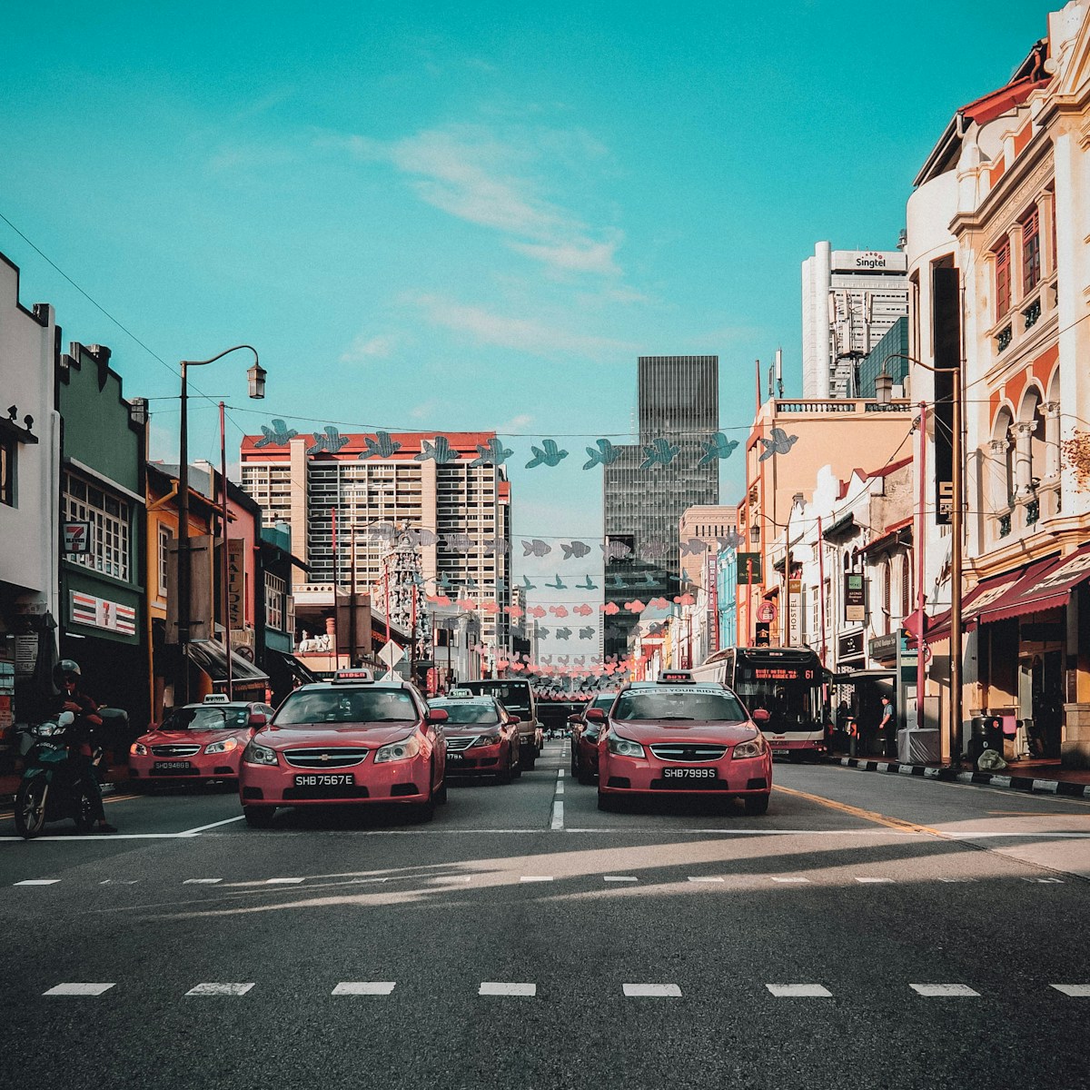 Cars driving on a city road in Singapore with modern buildings in the background